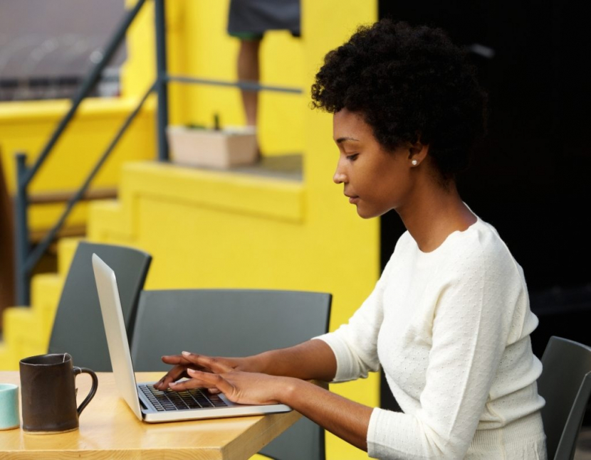 attractive-young-woman-using-laptop-outside-P9RLFGU-Jim-Fahad-Digital